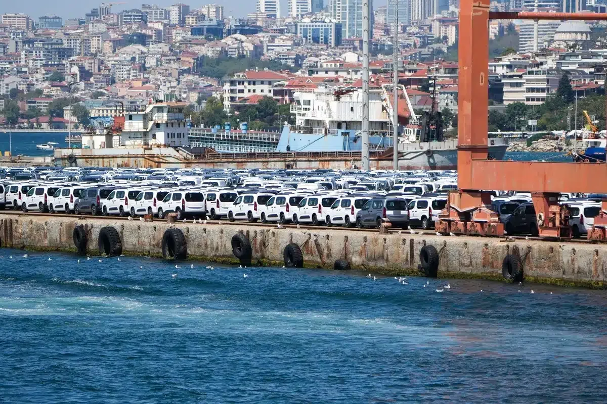 A large shipment of white cars at a bustling port in İstanbul, Türkiye.