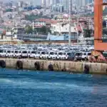 A large shipment of white cars at a bustling port in İstanbul, Türkiye.